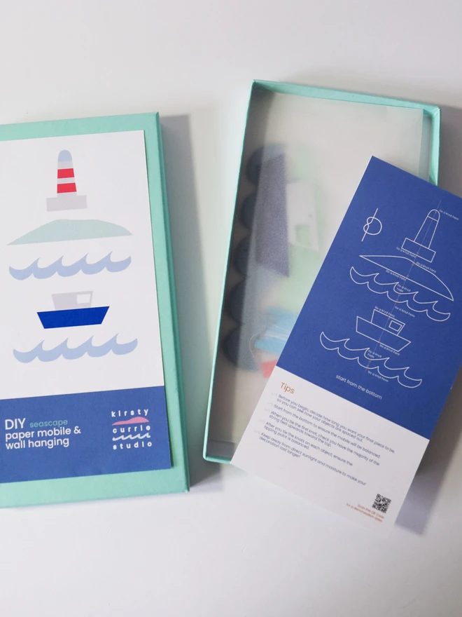 An open box with mobile parts and instructions in it