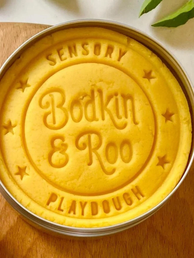 fairy sensory play dough sensory set. a tub of yellow play dough.