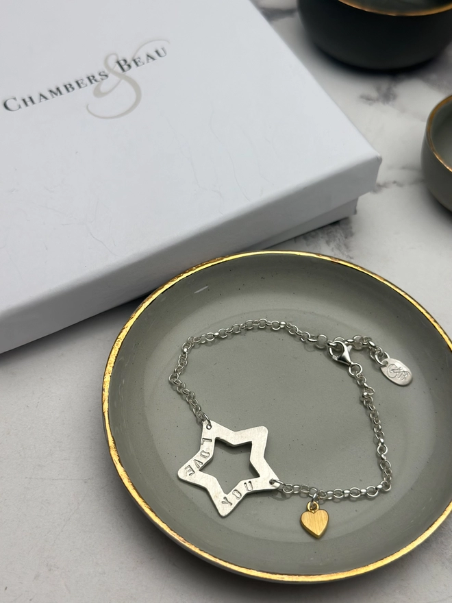 personalised sterling silver open star charm on a silver belcher chain bracelet with additional tiny heart charm in gold. gift box and pouch