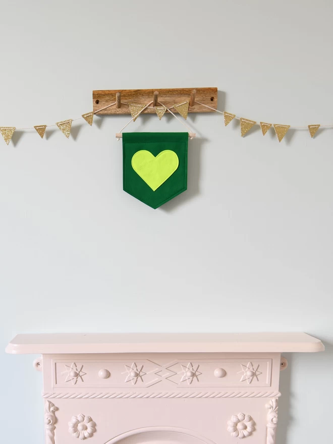 green felt banner with neon yellow heart sewn on.