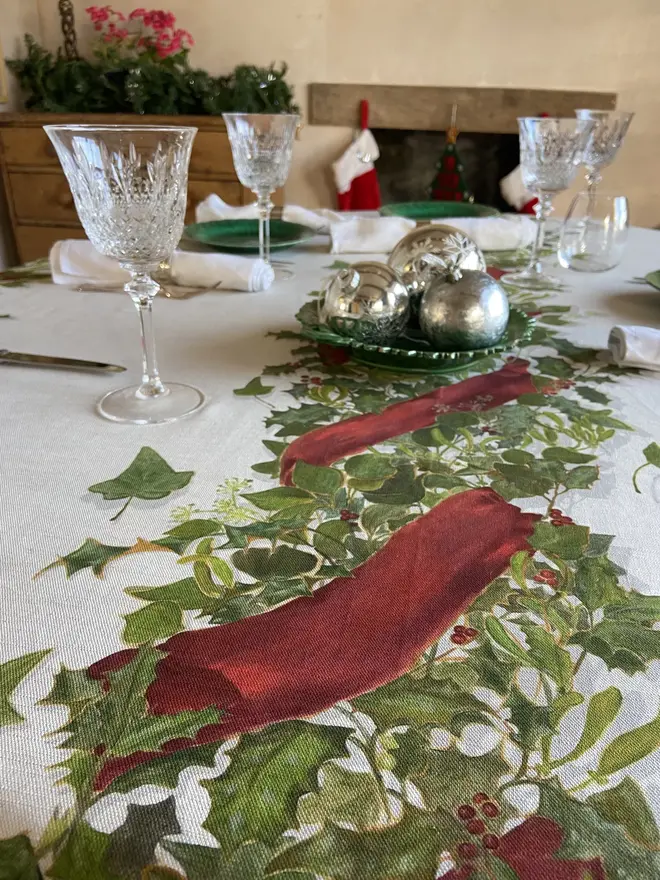 christmas garland centrepiece tablecloth. a white tablecloth emblazoned with a christmas garland on a table.