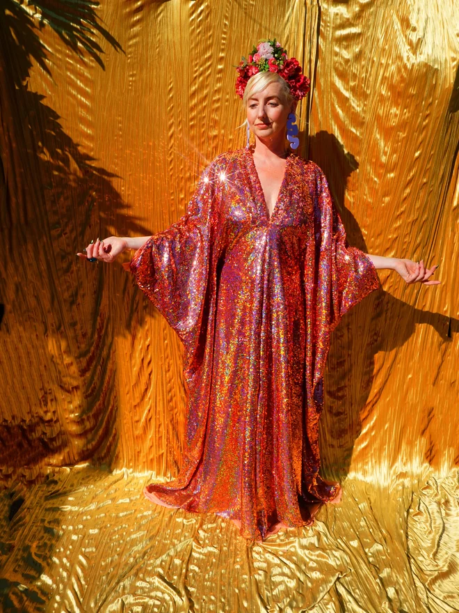 Rose Gold Holographic Sequin V-neck Kaftan Gown seen on a woman with her hands held out.