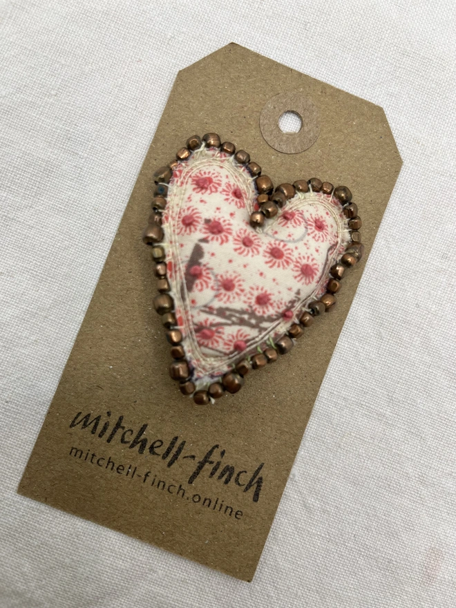 bronzed edged brooch on label