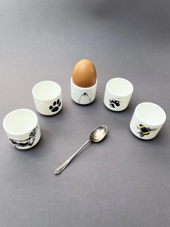 Five of the six egg cups showing Dachs and cockapoo paws, baby up, Dachshund and Peepo Maud egg cups