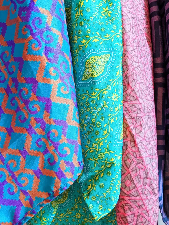 three different colour fabric options, purple, blue and orange pattern, green, blue and yellow pattern and pink and a light grey pattern