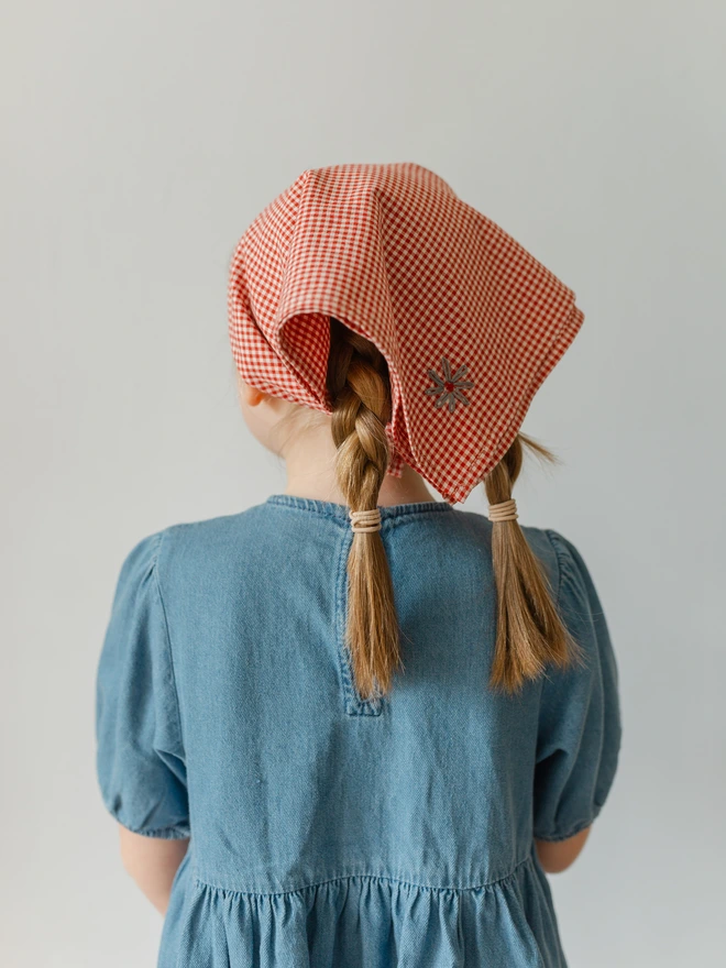 Girl with head bandana on showing flower embroidery