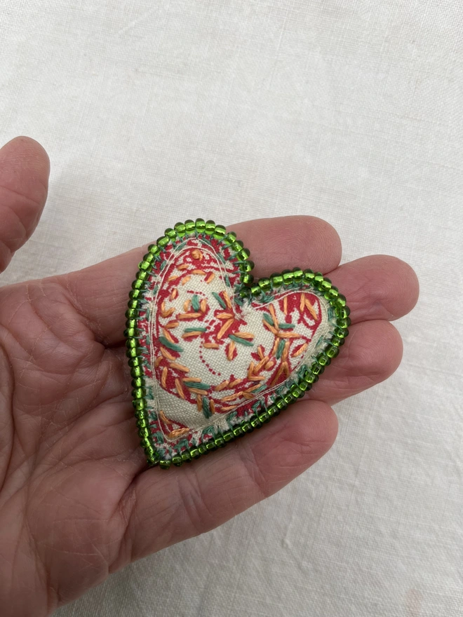 green beaded brooch on hand