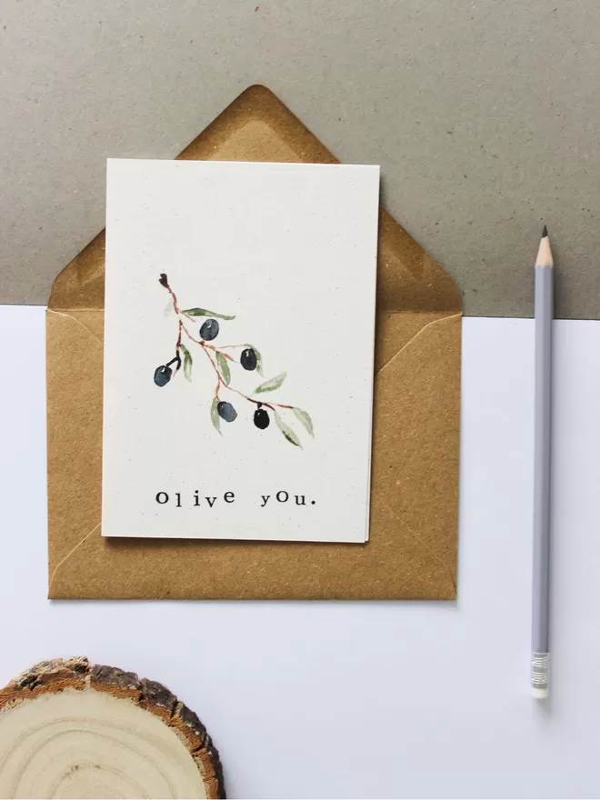 'Olive You' card laying on workspace with envelope