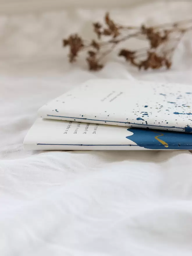 Hand stitching on the spine of blue and gold personalised notebooks