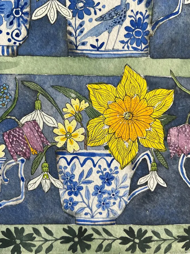 daffodils, snowdrops and spring flowers in delftware teacups displayed in a plant theatre