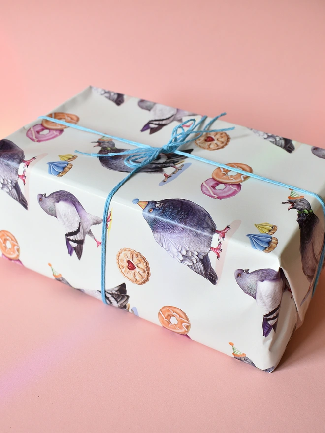 a gift wrapped in paper featuring hand illustrated pigeons and biscuits