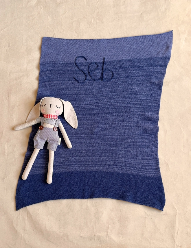 Denim blue and light blue baby blanket laid out flat