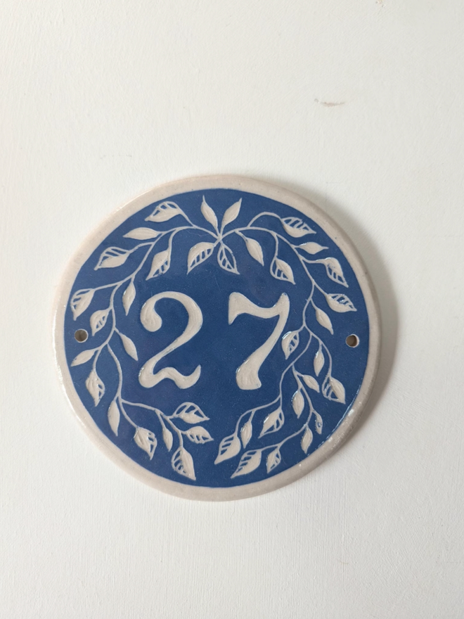 Custom Round Ceramic House Number with Leaves. A house number in blue.