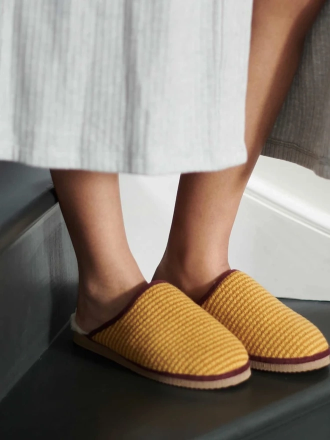 Lambswool & Sheepskin Slippers, a person wearing a pair of colourful lambswool and sheepskin slippers. 