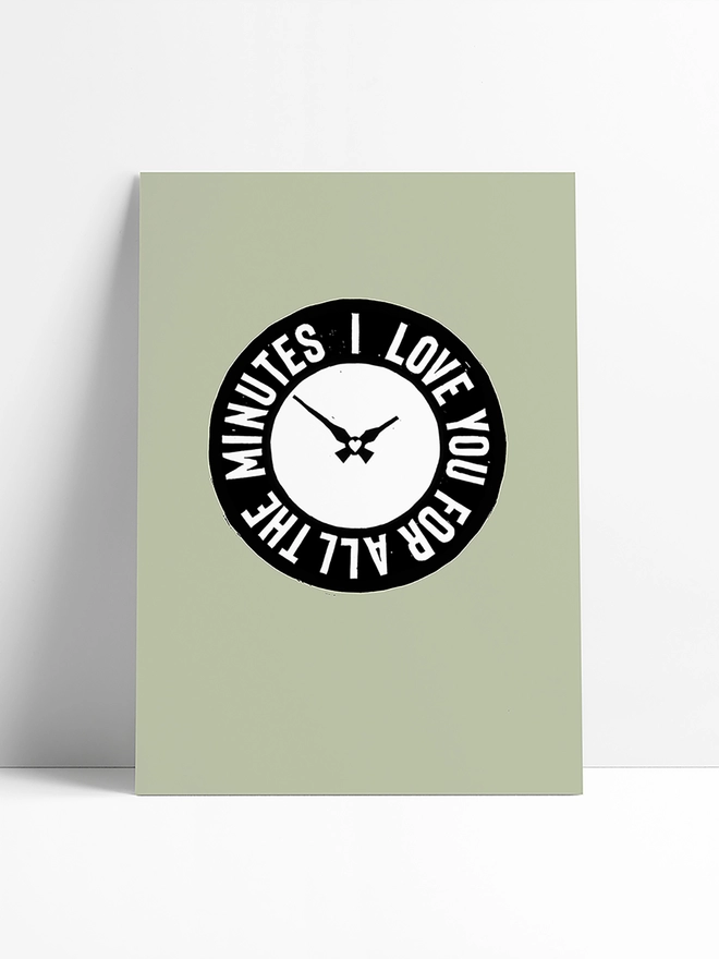 A green Woodism print in a limbo background, featuring a black clock with white typography which reads: I Love You For All The Minutes.