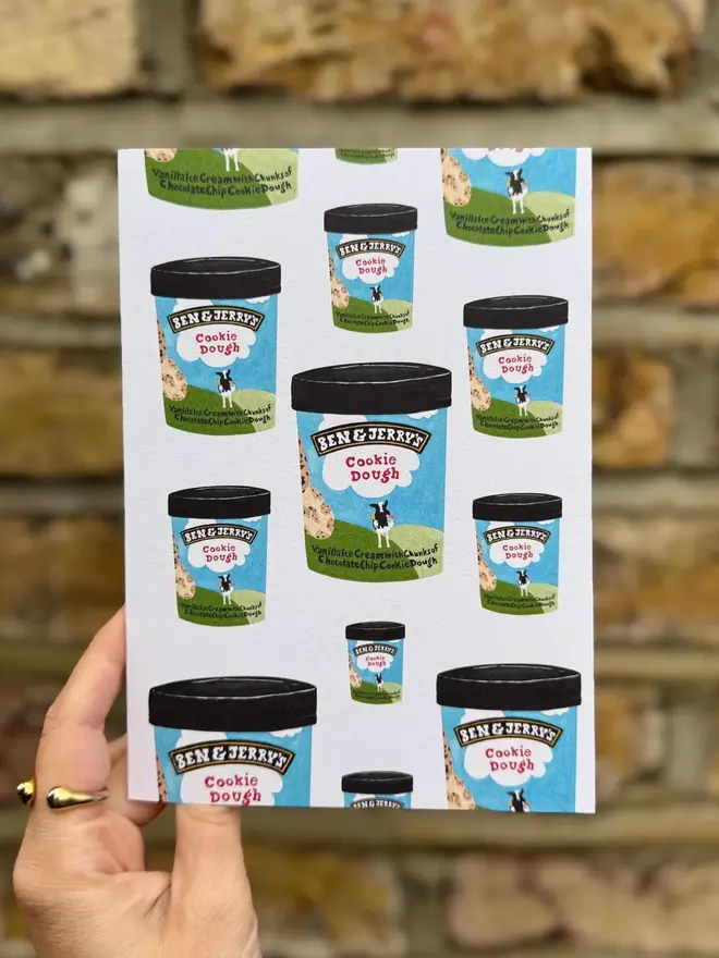 cookie dough ice cream illustrated card. card photographed against brick wall backdrop. 