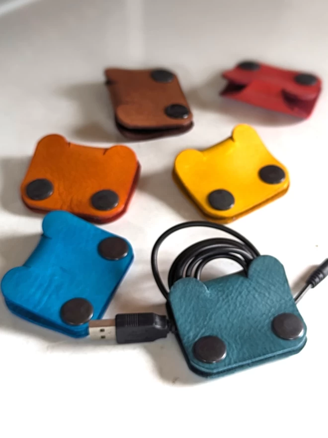 Image of leather Bear cable tidies in an assortment of colours.
