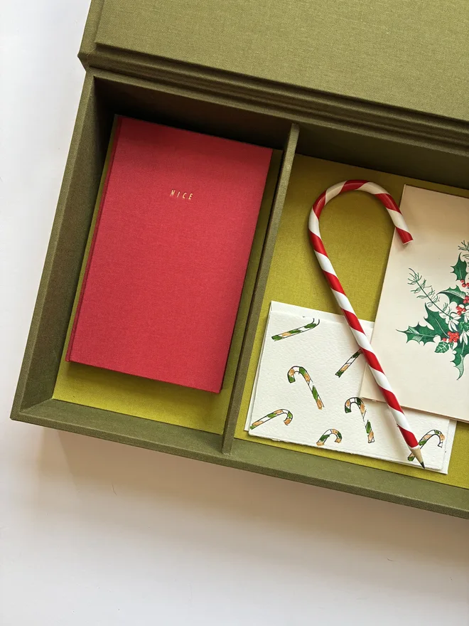 Open handmade Christmas Correspondence box in Olive green cloth displaying cards and stationery items including Keep Collect Christmas Naughty or Nice notebook