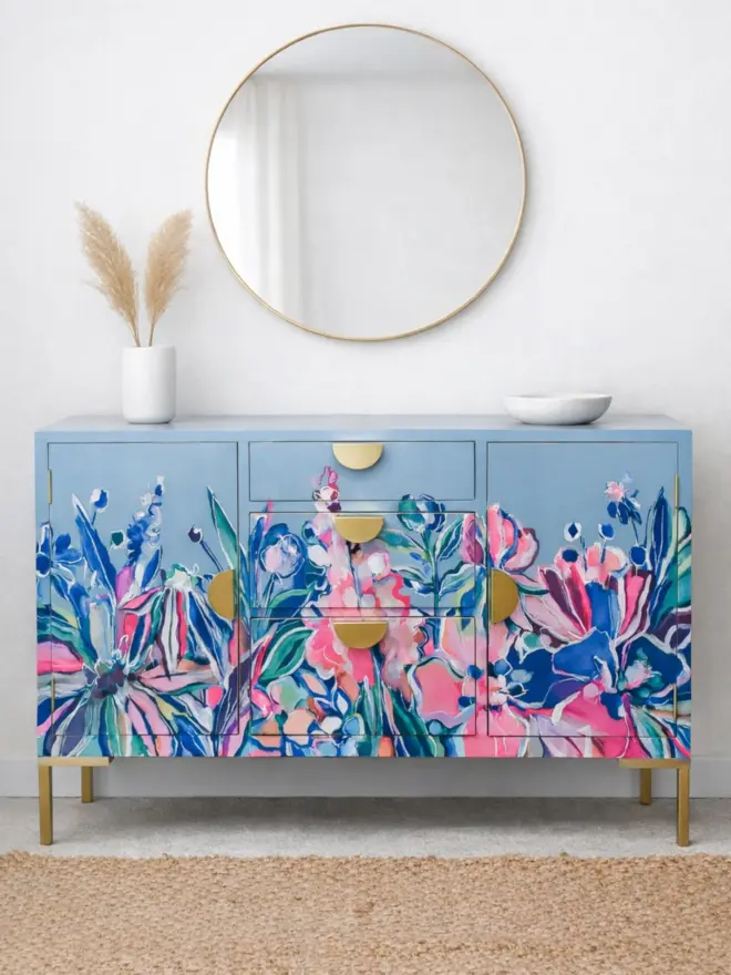 Floral Hand-painted Sideboard staged with rustic jute rug and pampas grass, white tableware and brass edged circular mirror. This piece is vintage and remodelled from a 1930’s piece. 
