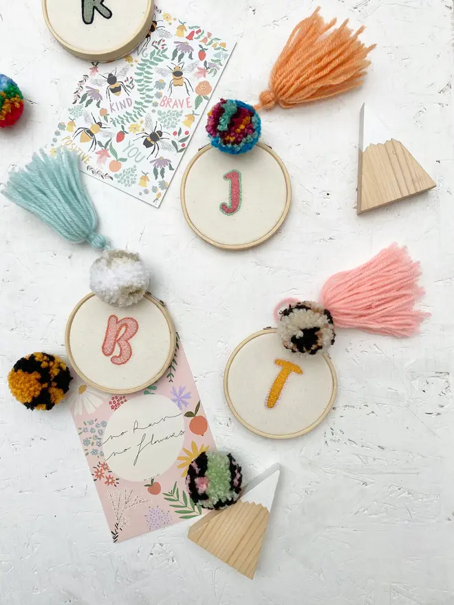 custom letter or number embroidered hoop. selection of cotton hoops embroidered with various letters and numbers in a variety of colours.