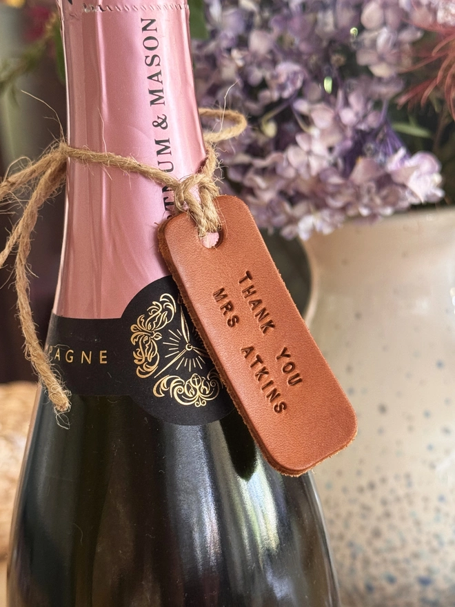 Tan leather teacher label on a bottle of champagne