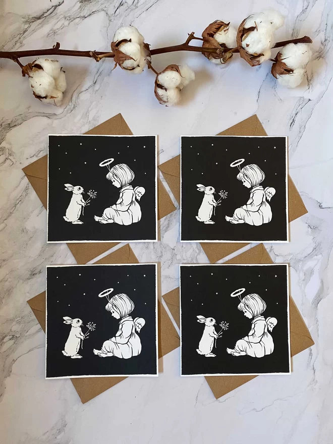 4 beautifully printed Christmas cards featuring bunnies and a girl angle in the snow