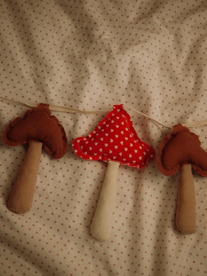 Mushroom Garland DecorationMushroom Garland Decoration, a mushroom garland sitting on a child's bed. 
