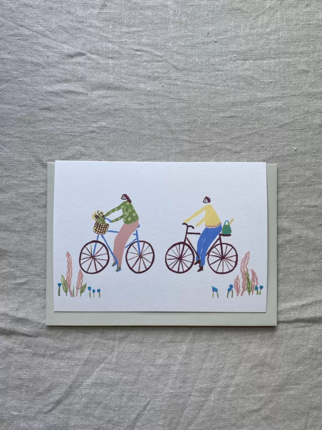 girl and boy on a bike greetings card