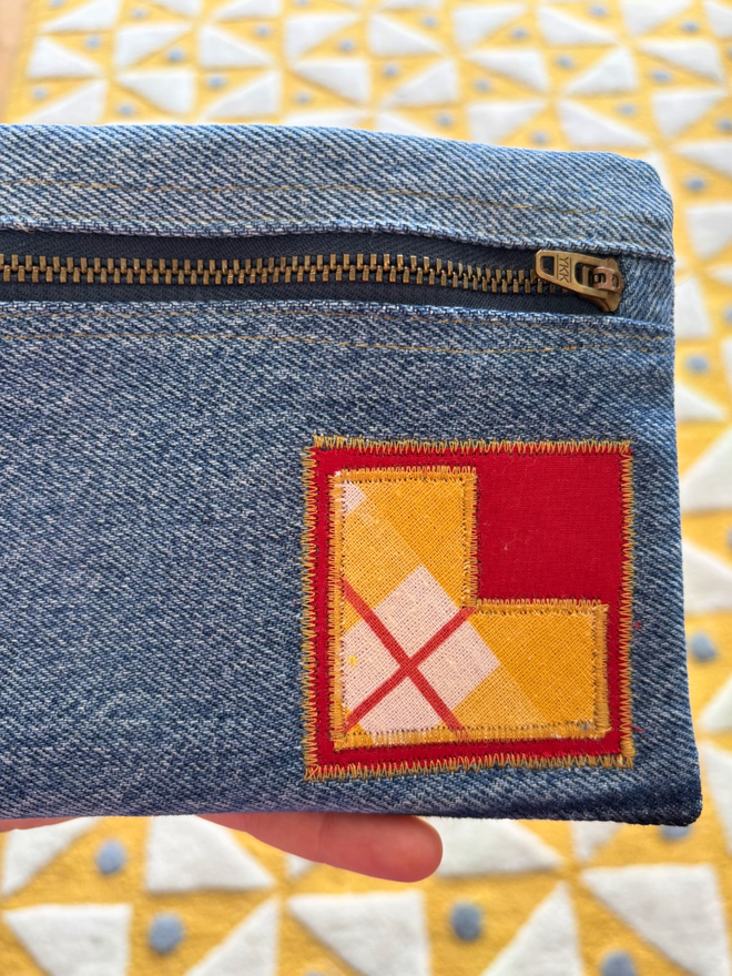Handmade pencil case made from reclaimed denim with a zip fastening and a bright vintage‑print initial on the front