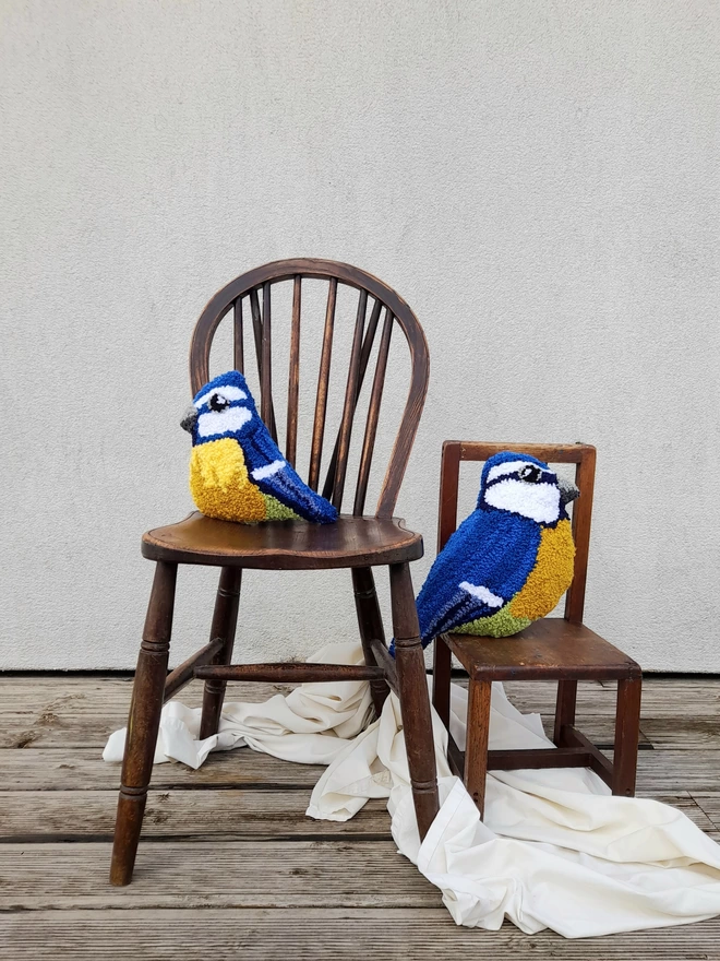 Small and Large Blue Tit Decorative Cushions on Vintage Wooden Chairs 