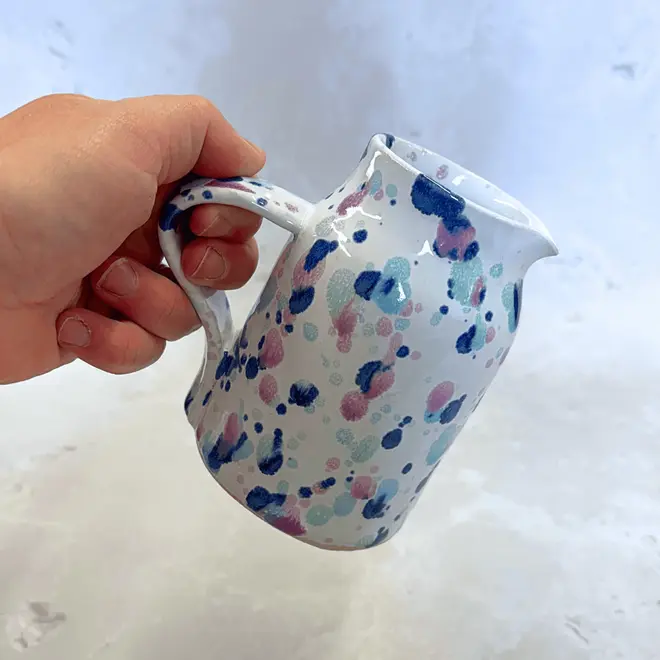 Sweetpea Small Jug, a colourful jug placed on a stone surface. 