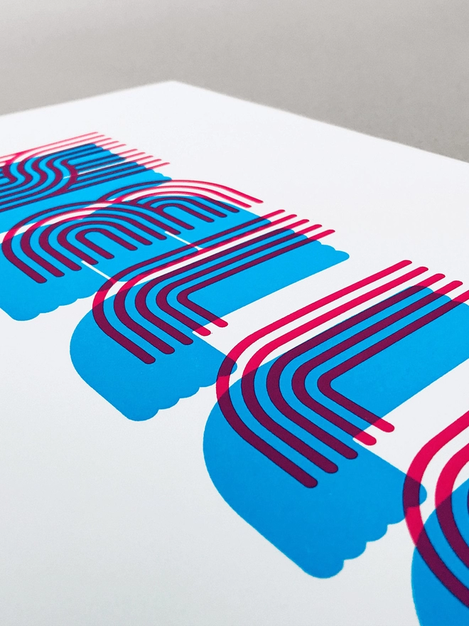 Close up of this print stripy tram lines make up this font in a retro/sporty look. Hello is screenprinted in this font in magenta, with a cyan solid shadow beneath. 