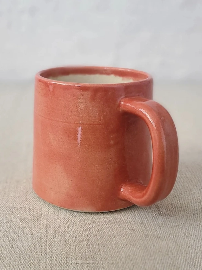 Ceramic Standard Mug, a colourful ceramic mug sitting on a plain surface against a grey backdrop. 