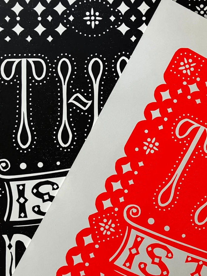 this is the place linocut. a linocut phrase printed with black and red paint.