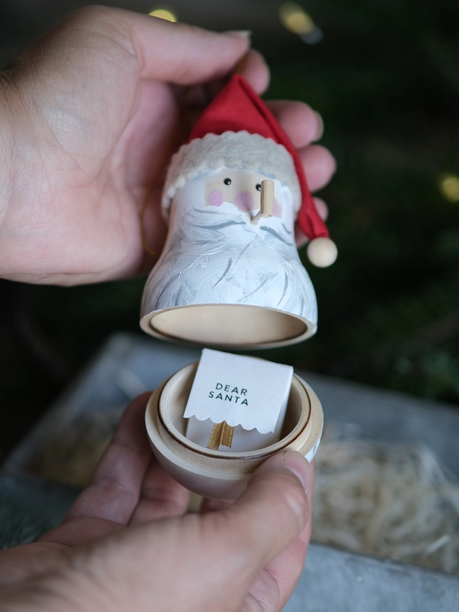 Handmade rustic Santa Christmas ornament with a white beard, rosy cheeks and red hat, with a tiny note to santa inside