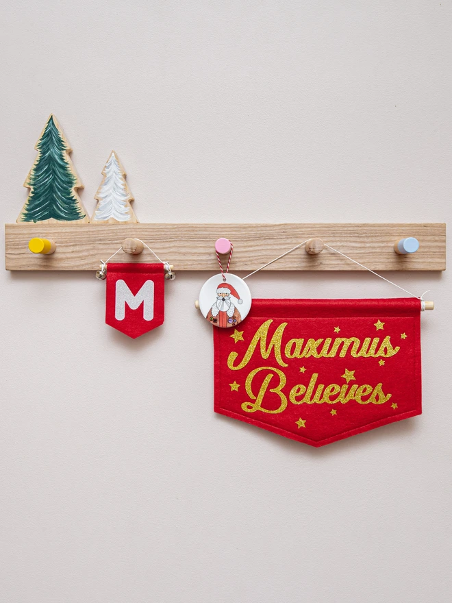 Personalised "Believes" Christmas banner in red felt and gold glitter.