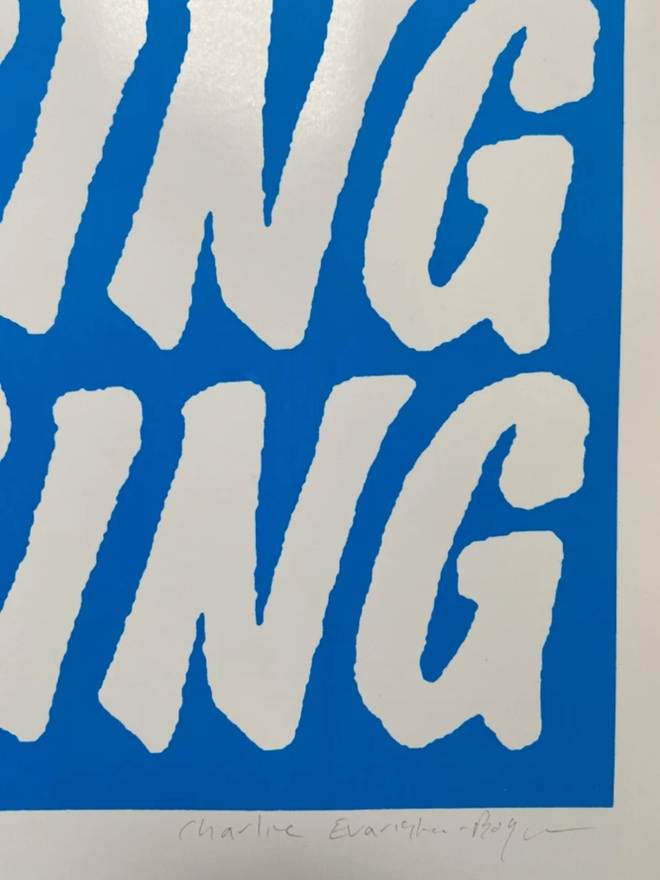 Fluoro Amazing Print. Close up of a print with a vibrant blue background with AMAZING written five times.