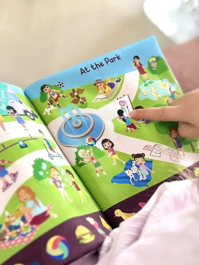 Girl pointing at painting on Can you find Teddy? Search and find soft book