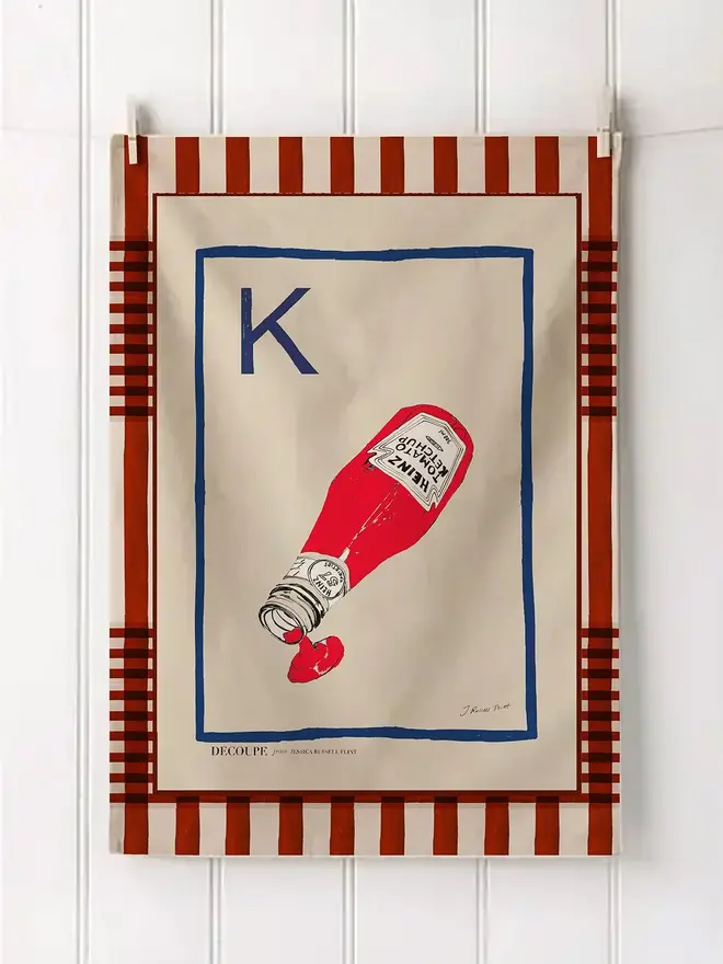 a-z alphabet tea towel. a tea towel with a ketchup print and the letter 'k' in the corner.