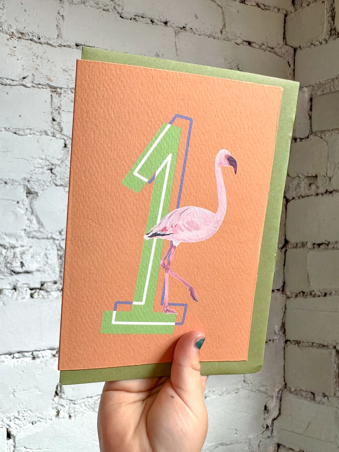 an orange card with a big green number 1 and a flamingo illustration with a green envelope
