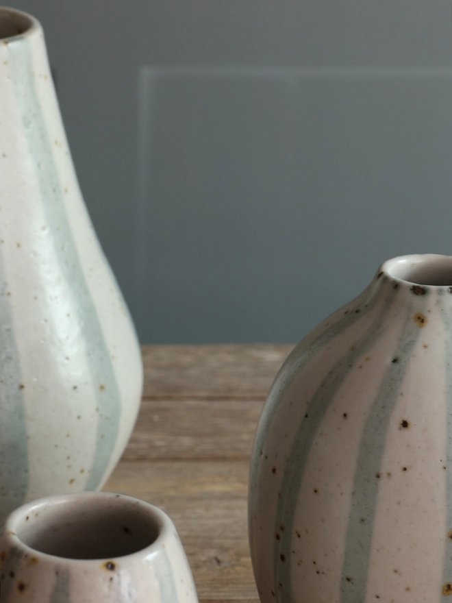 Close-up photograph of three Handmade Ceramic Stoneware Vases in Blue and White Stripe. 