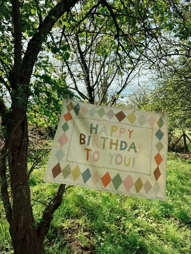 Heirloom Fabric Birthday Banner, hanging in a tree. 