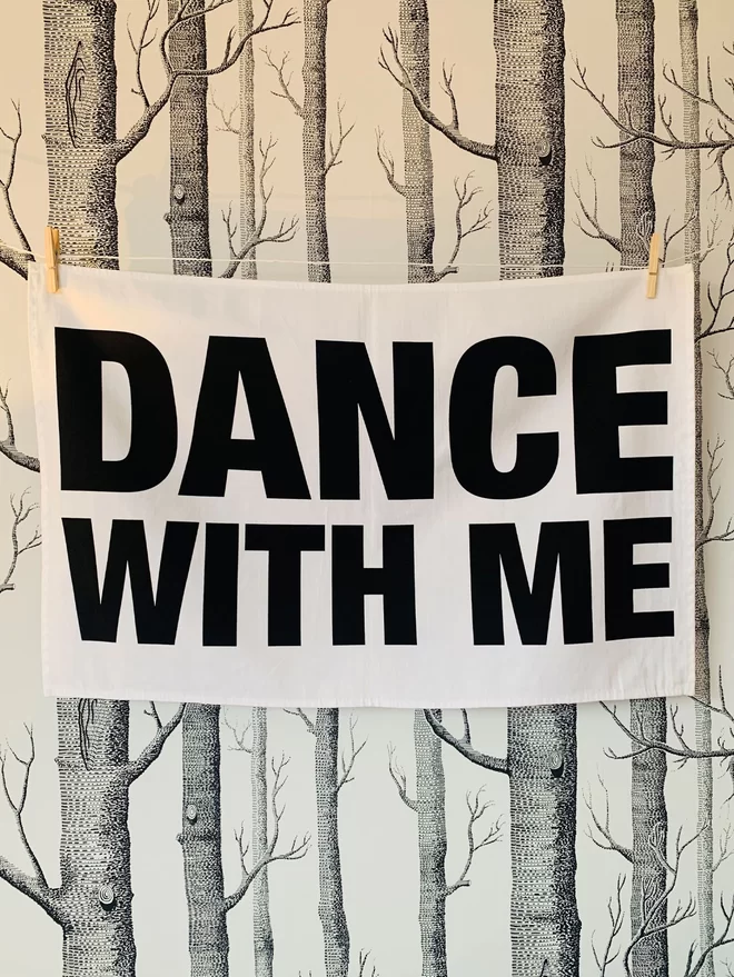 London Drying Dance With Me black text on white tea towel hanging washing line style in front of white with black silver birch trees woods pattern wallpaper