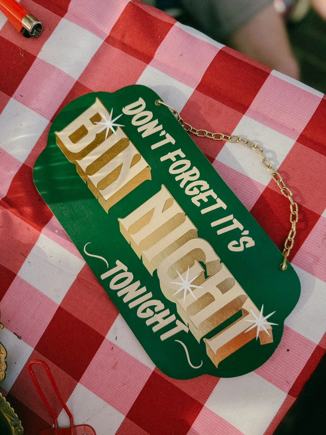 green 'dont forget it's bin night tonight' sign with gold text and hanging chain