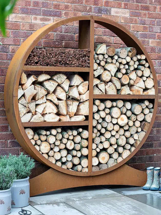 Oakham Log Store, log store filled with wood stacked in garden. 