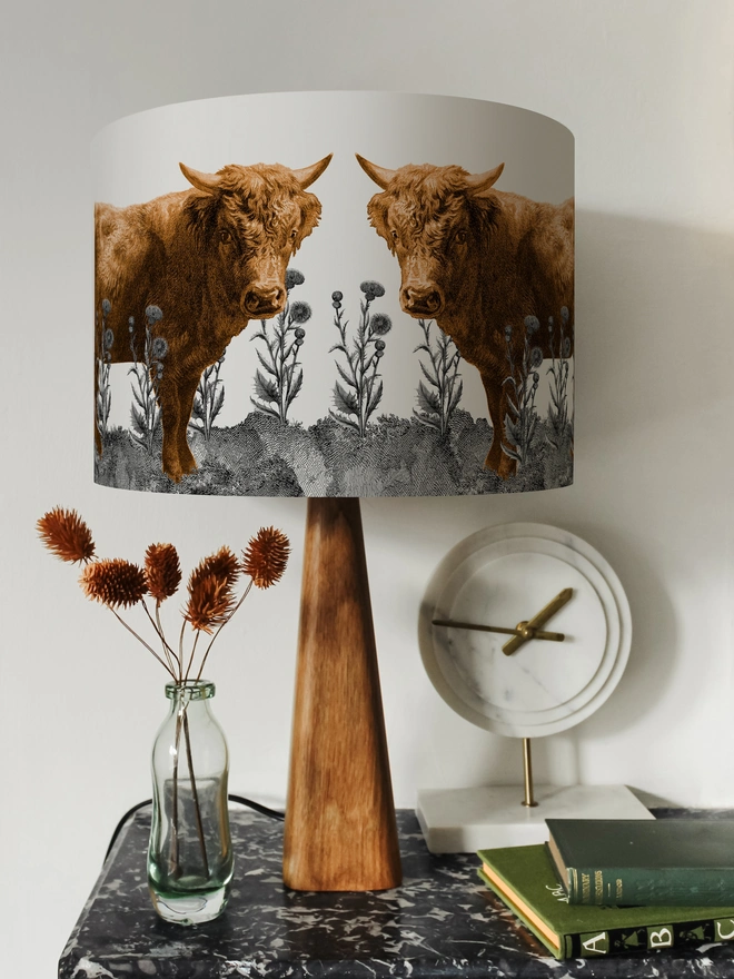 Lampshade of Highland Cow in a field of Scottish thistles