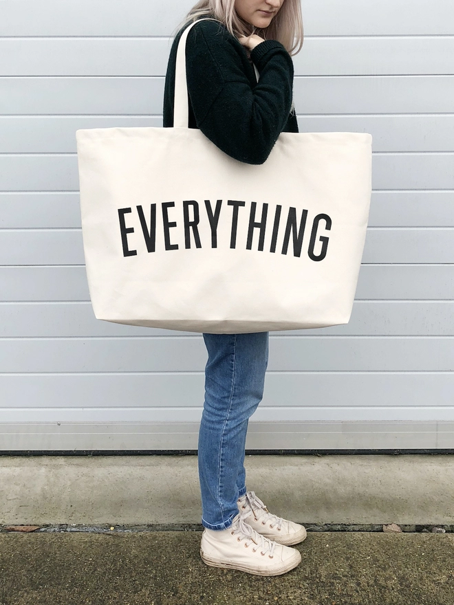 Model carrying the Everything oversized tote bag in natural canvas