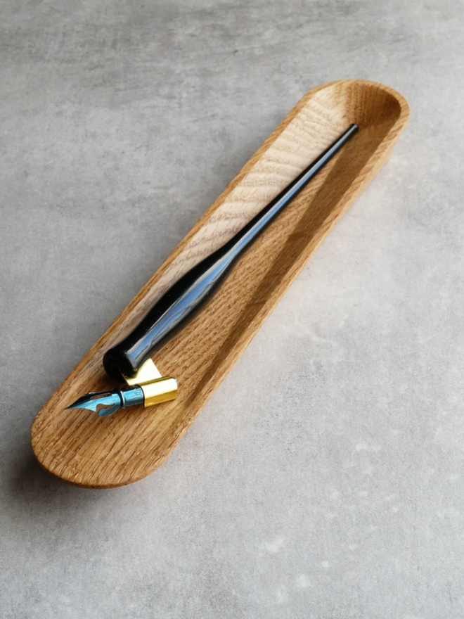Pen Rest. The Oak pen rest with a dip pen inside.