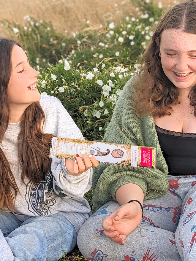 2 happy girls holding joyful heart well being charity incense sticks in peach & gold illustrations