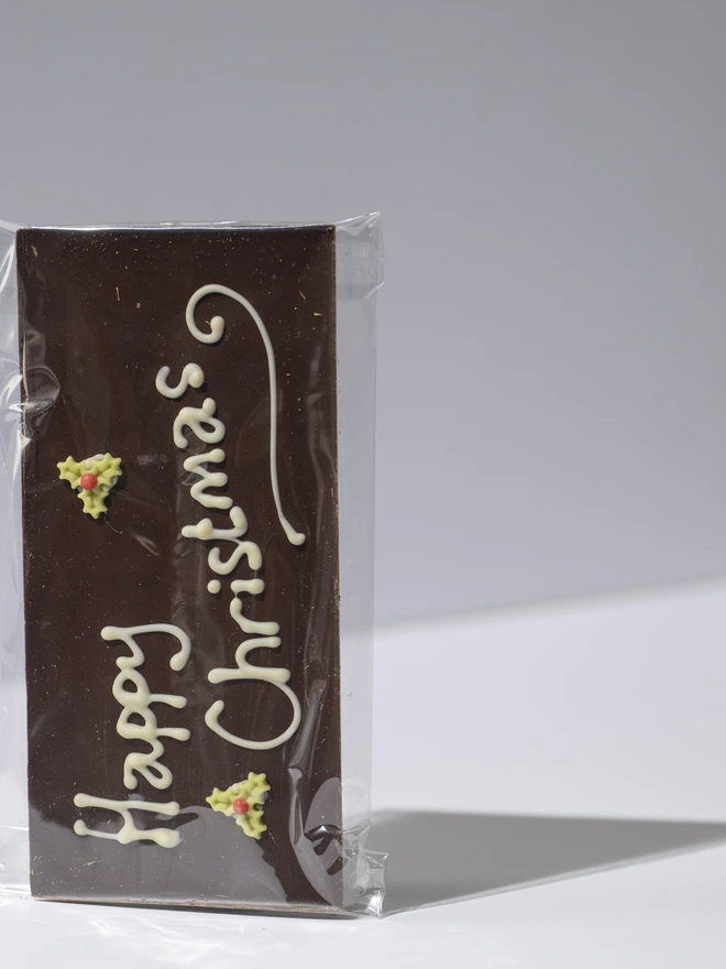 A dark, Milk or white chocolate solid bar with a hand piped Happy Christmas message and edible stars